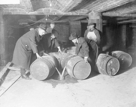 Agentes federales destruyen barriles de bebidas alcohólicas en 1921.