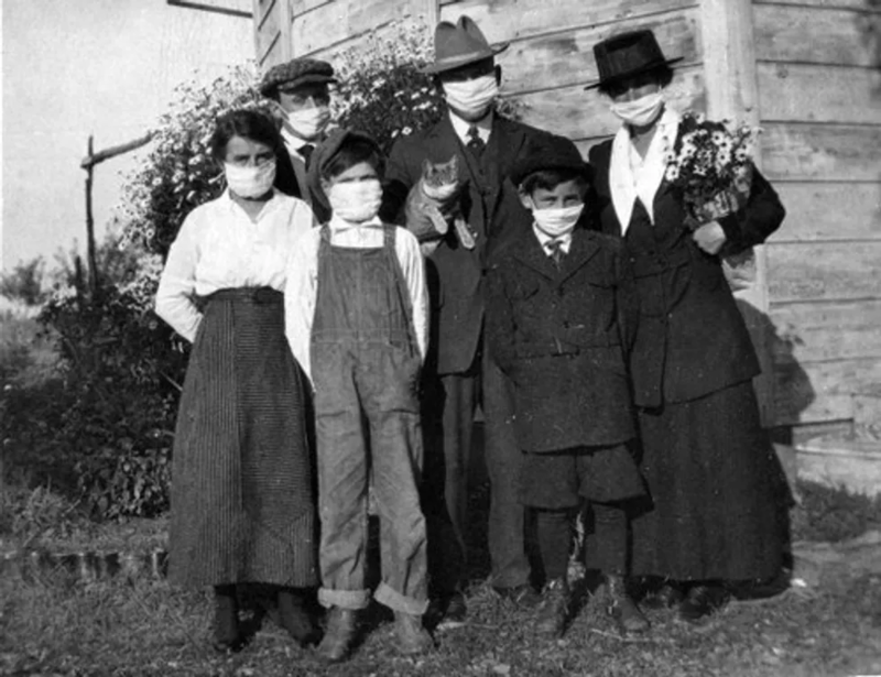 Fotografía de autor desconocido que retrata una familia con máscaras protectoras (1918).